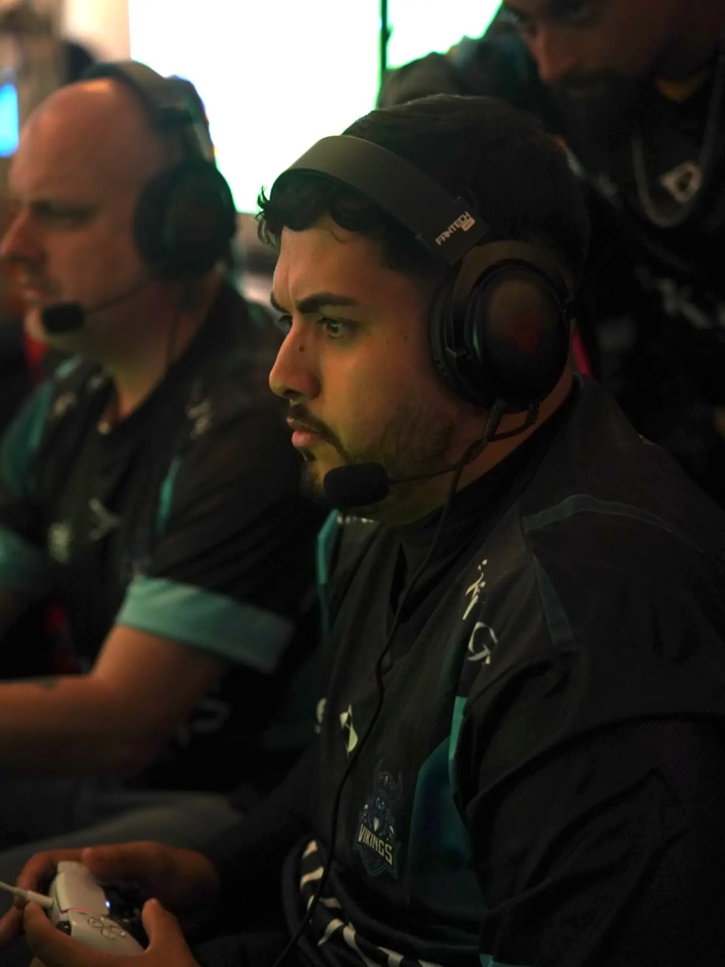 Atletas da Vikings em partida, de headset e controle em mãos