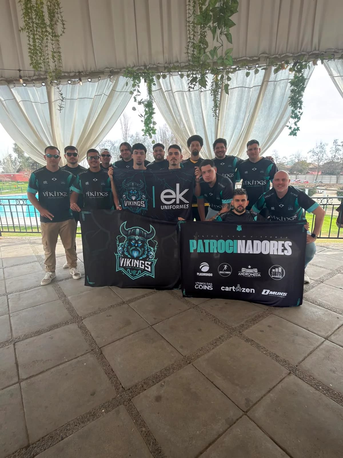 Elenco da Vikings reunido com a bandeira dos patrocinadores